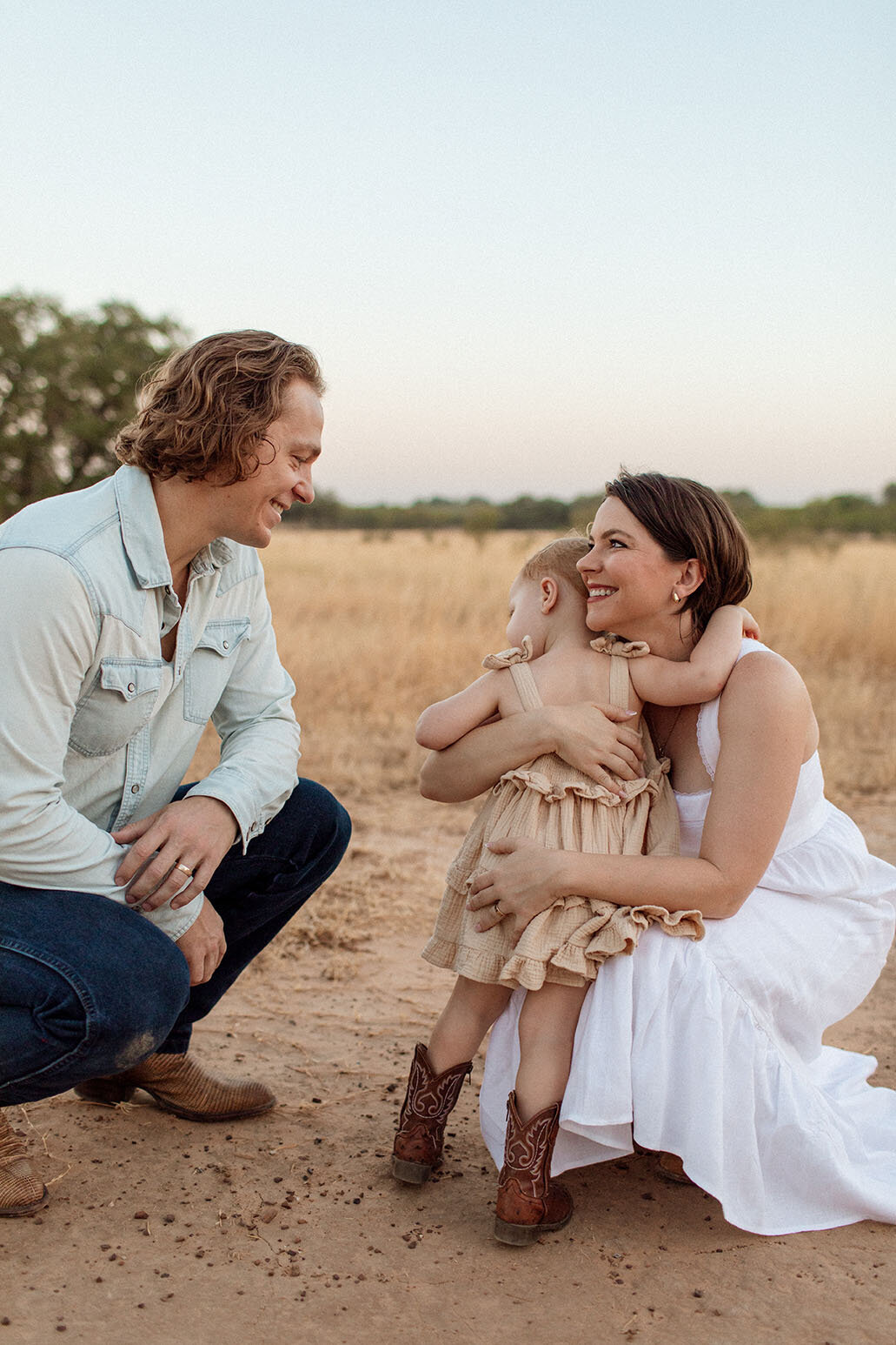 Daughter embracing mother in open field during family photo session - Sara James captures tender mother-daughter moments and family bonds in beautiful San Antonio Texas outdoor locations