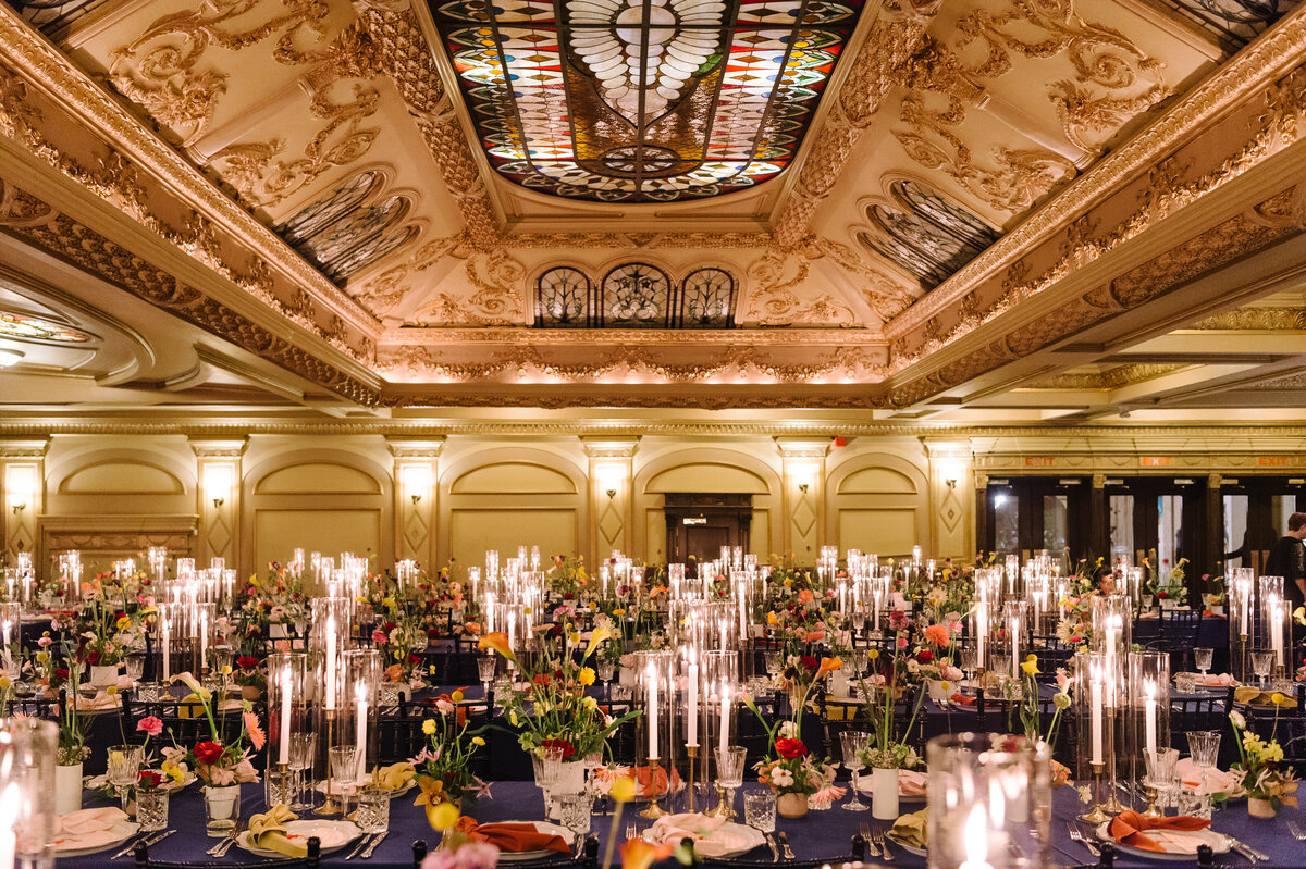 Colourful floral centrepieces and decor for a wedding reception under the picturesque ceiling of the Rialto.