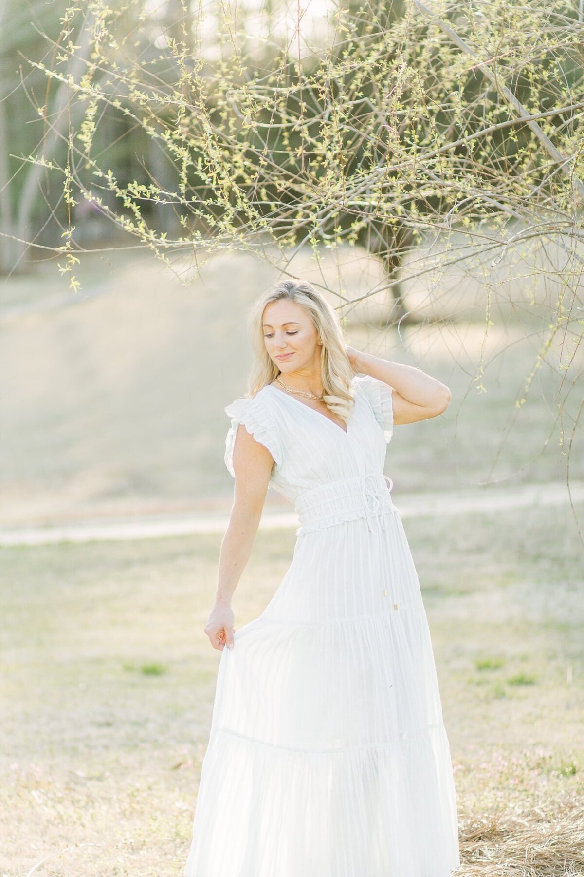 Woman posing in a white dress in a field