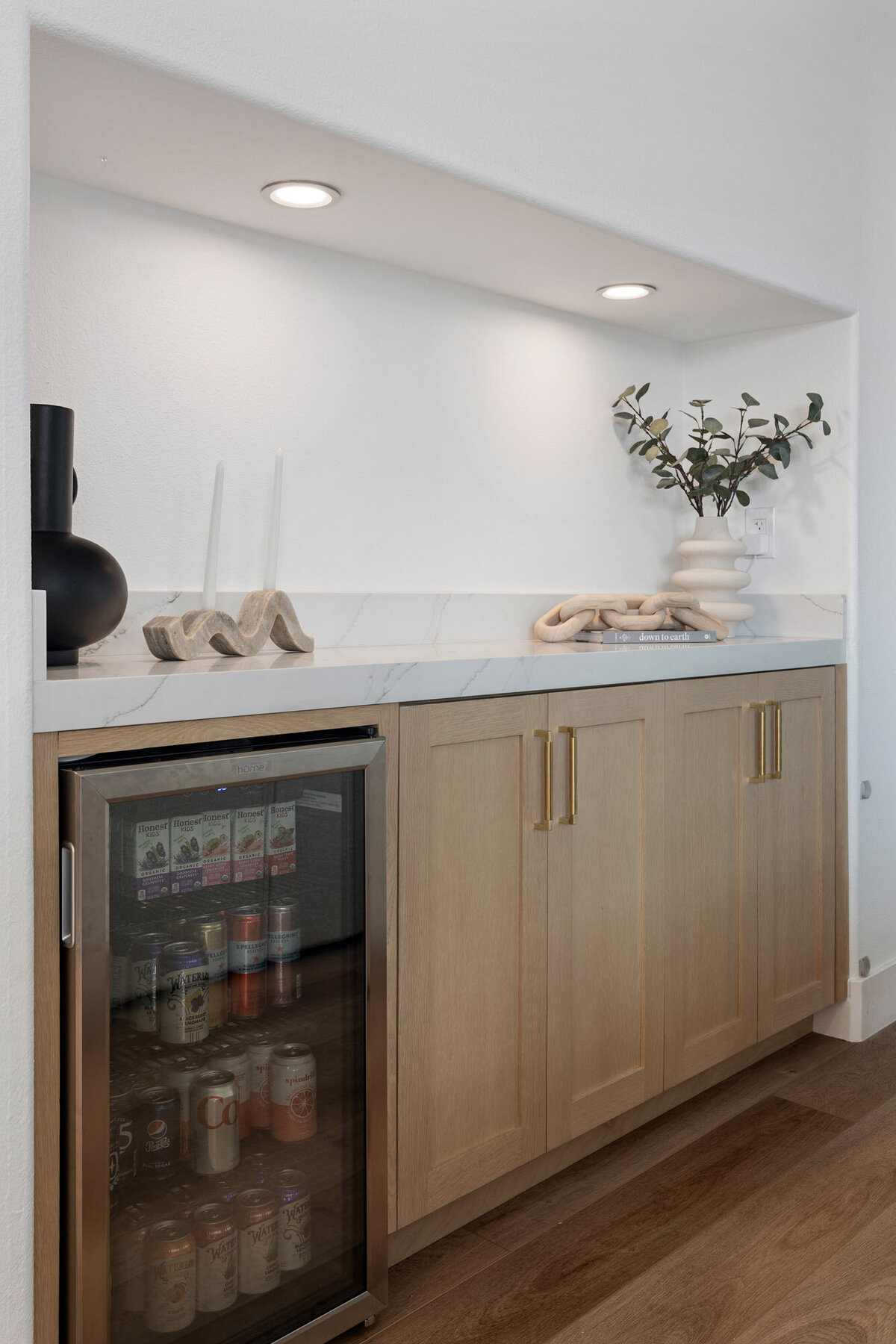 very culinary enthusiast would appreciate the blend of form and function in this space. The expansive marble-topped island is perfect for meal prep, and the state-of-the-art appliances promise efficiency. Natural wood elements balance the modern design.
