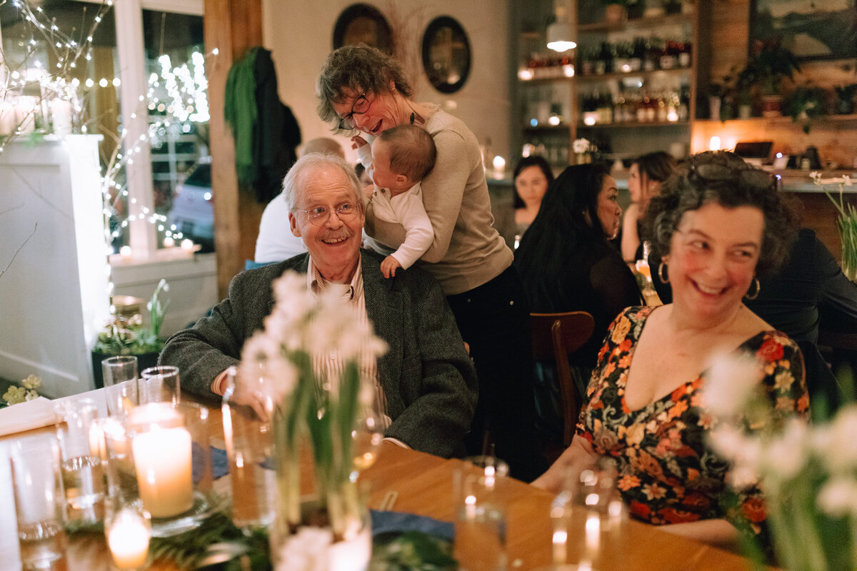 Photograph of baby kissing grandpa during an intimate wedding reception at Fairweather restaurant in Portland, Oregon.