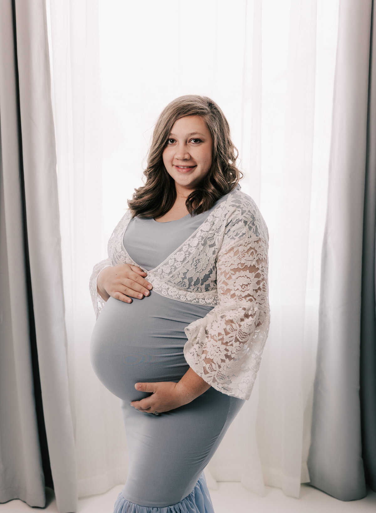 Bright white backlit photo of a pregnant mother.