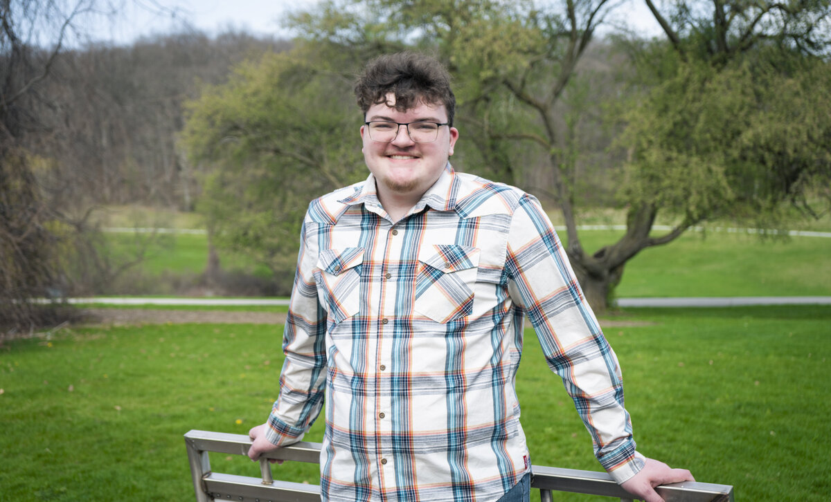 Senior portrait of a young man in a flannel shirt
