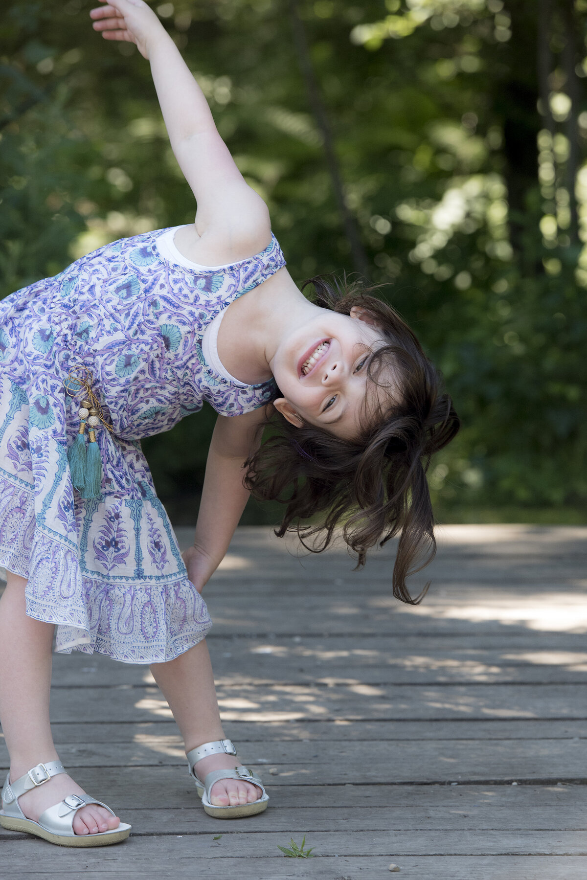 A child leaning over and smiling 