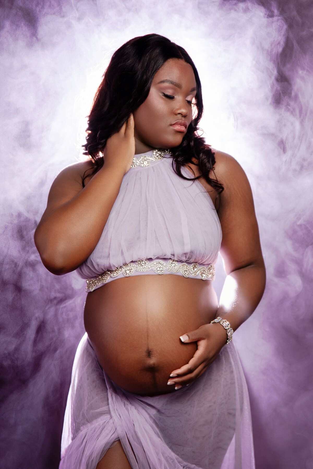 st-louis-maternity-photographer-woman-in-two-piece-purple-tulle-dress-with-belly-showing-and-backlight-with-smoke