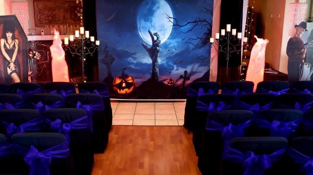 Halloween full moon with hand  coming out of grave backdrop with antique candelabra and flames to left and right