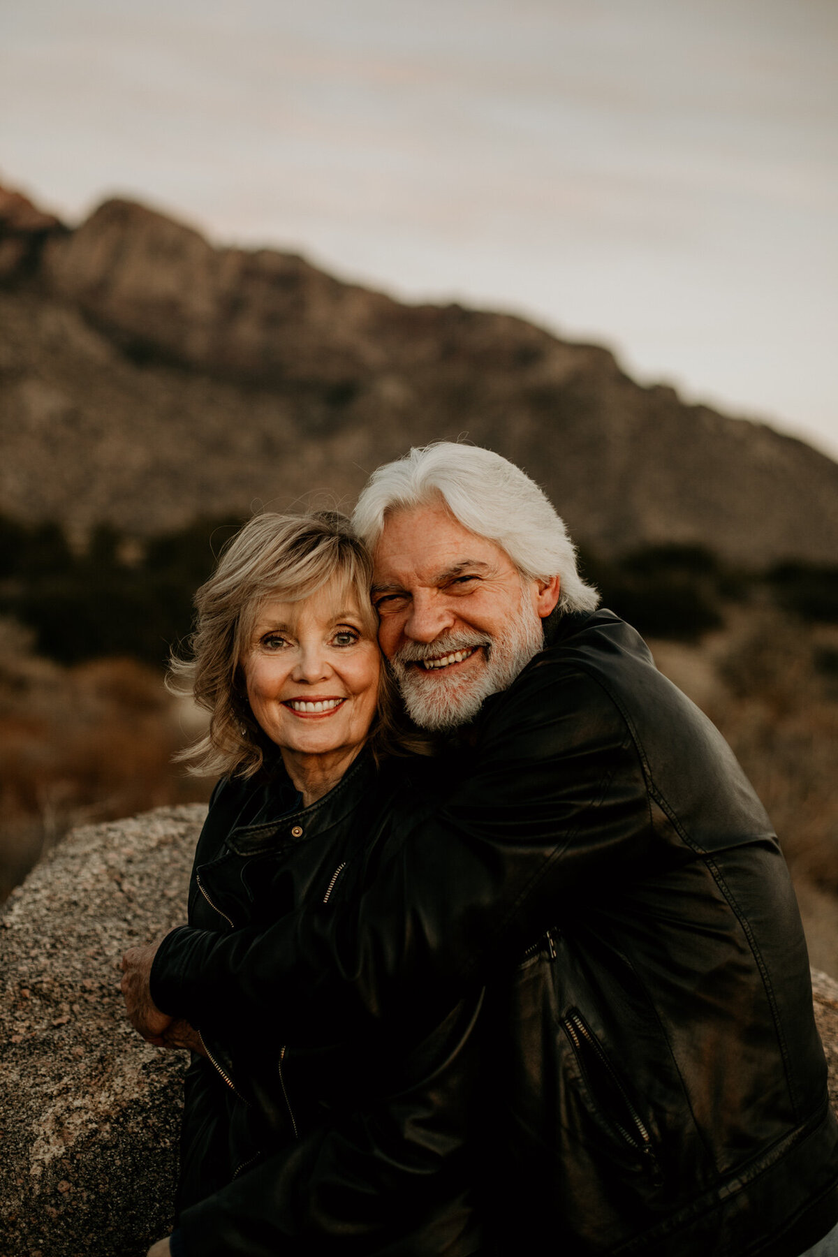 middle aged couple hugging and smiling at the camera