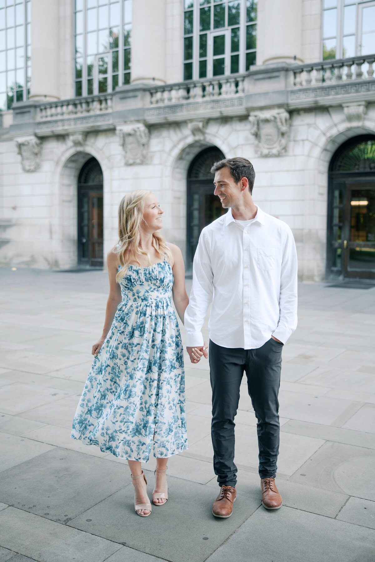 Engaged couple holds hands outside Columbus landmark, captured by Philly-based photographer.
