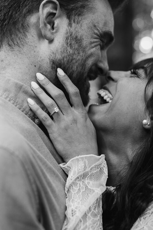 A woman laughs with her fiancee as they embrace for a kiss