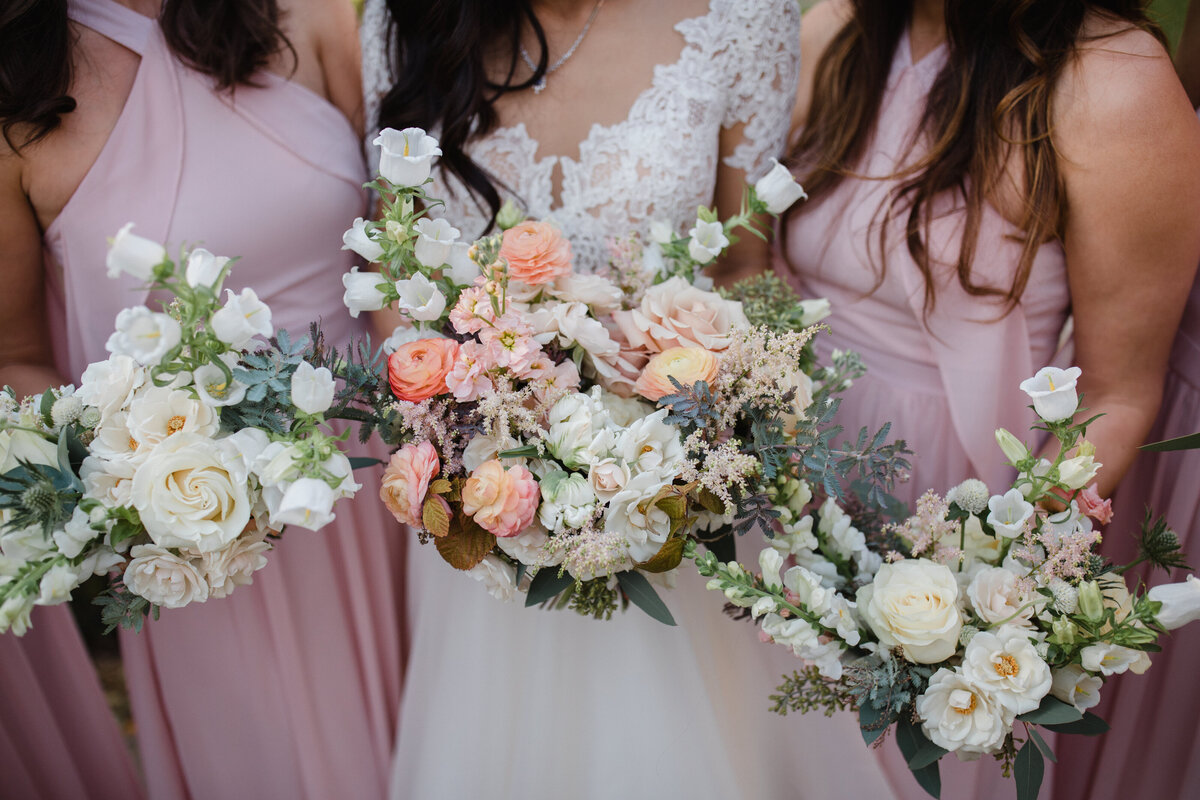 A bridal party hold bouquets of pink garden flowers at a Montreal wedding.