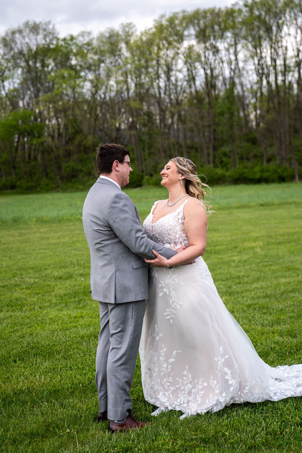 Bride and groom gazing at each other in an open field