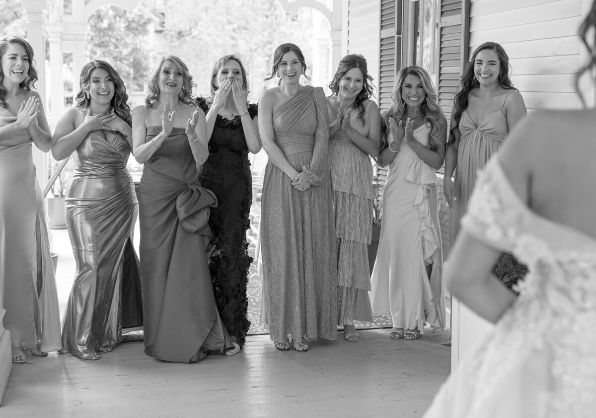 Bridesmaids joyfully react to seeing Bride in her wedding dress.