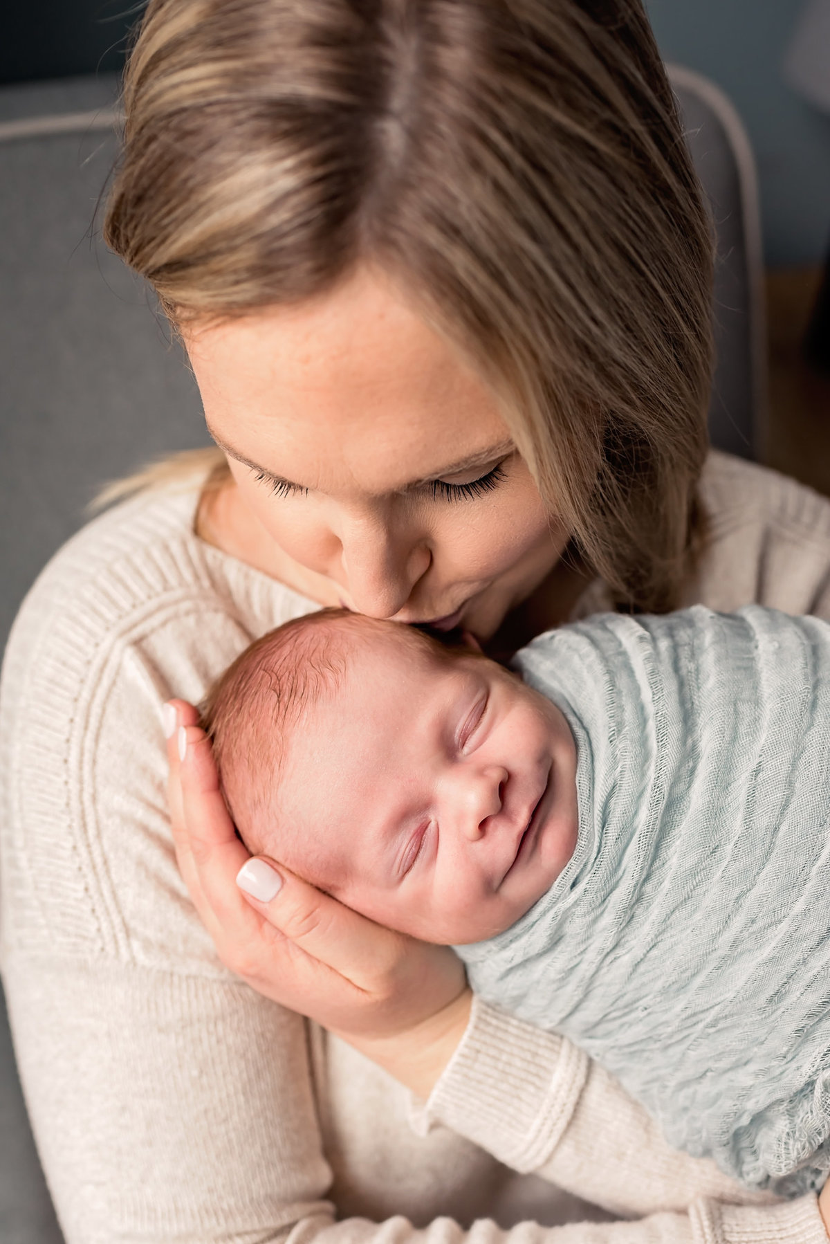 mom holding newborn son baby is smiling los angeles newborn pictures