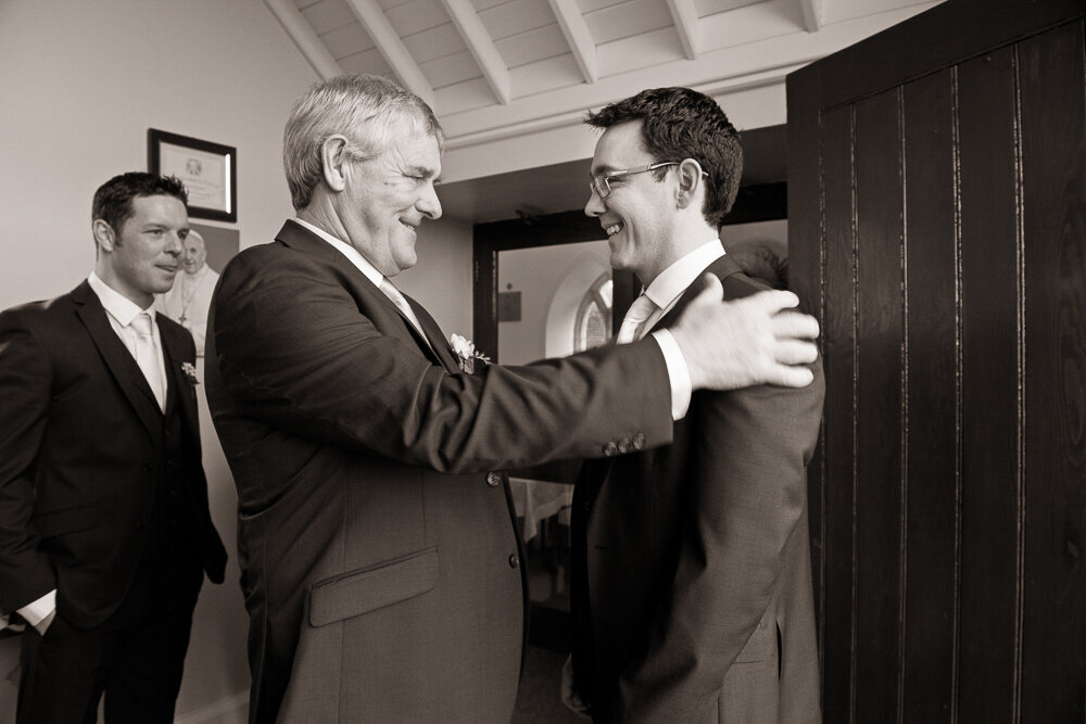 father of the groom congratulating his son after wedding ceremony