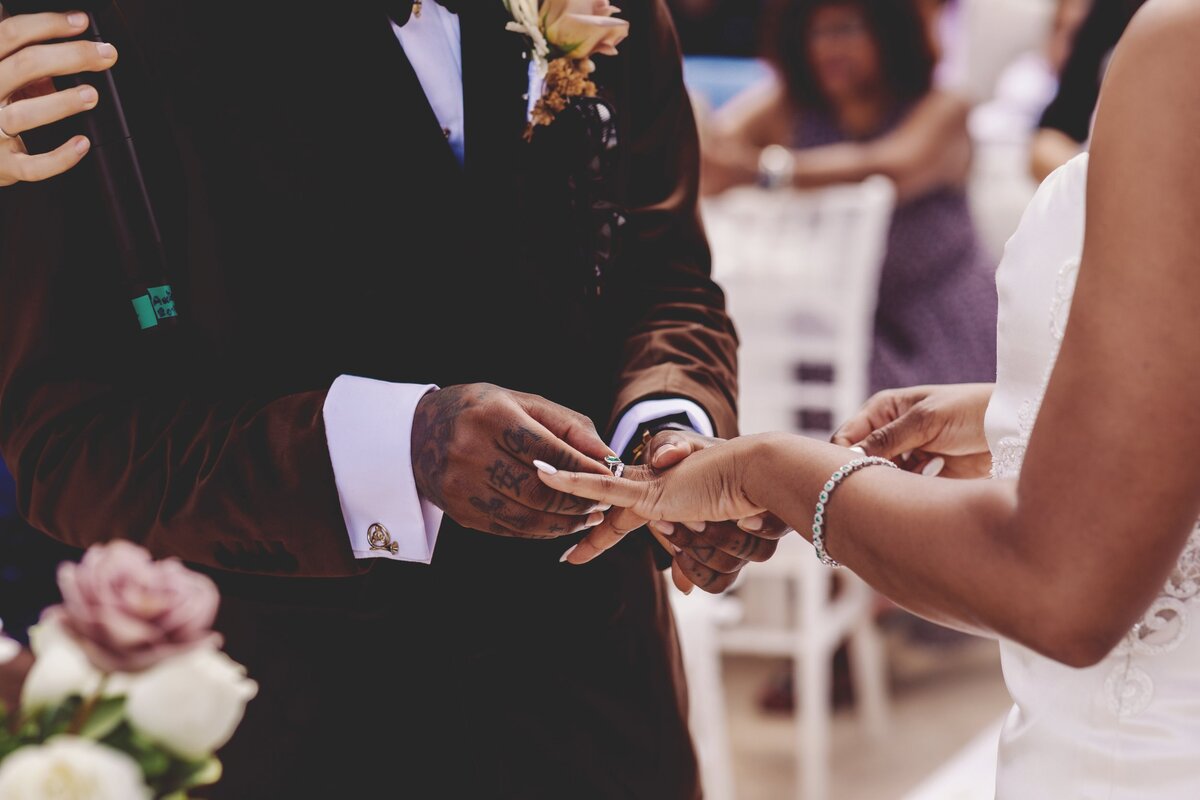 Close up of groom putting ring on bride at wedding in Cancun