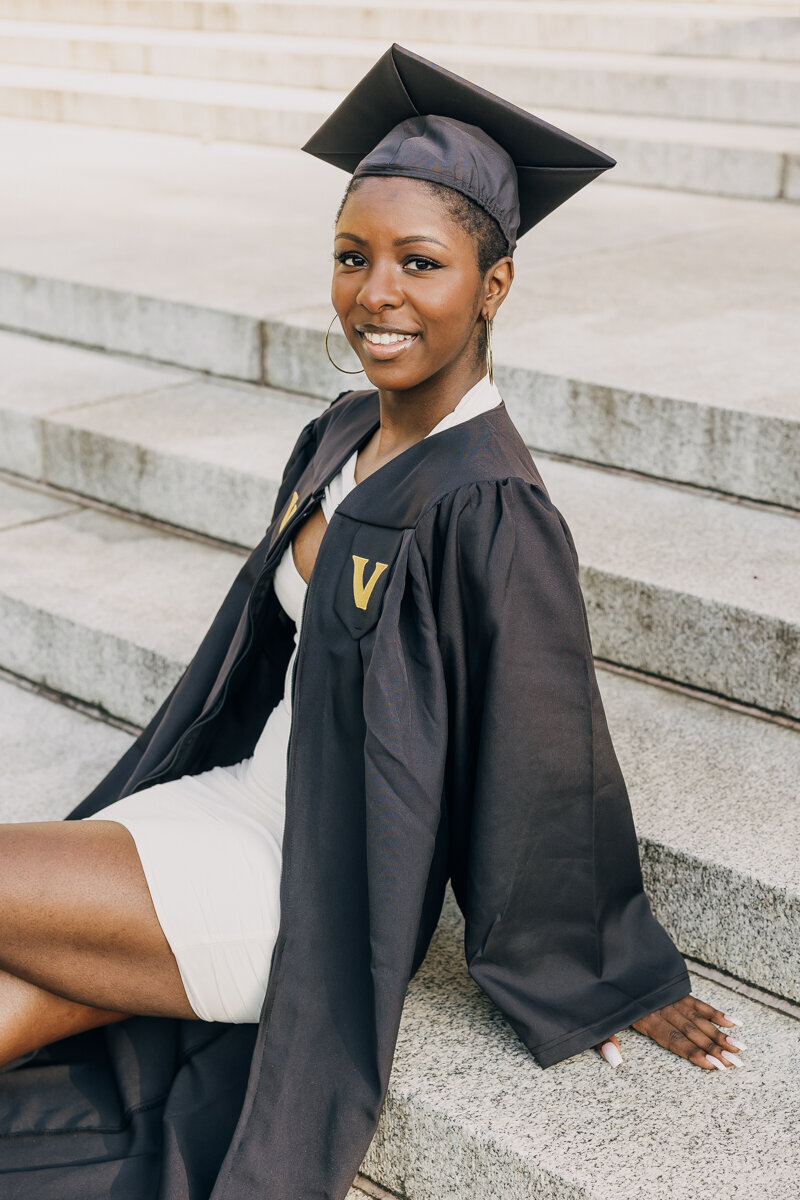 Vanderbilt grad sitting cross legged on the steps at Wyatt Center