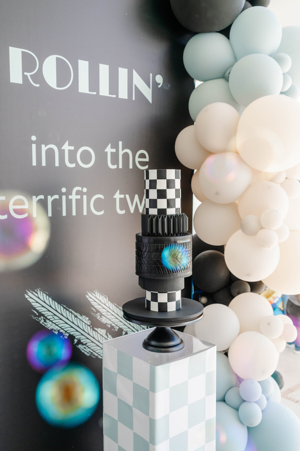 bubbles floating around vintage gravity defying cake with black and white checker and tire marks
