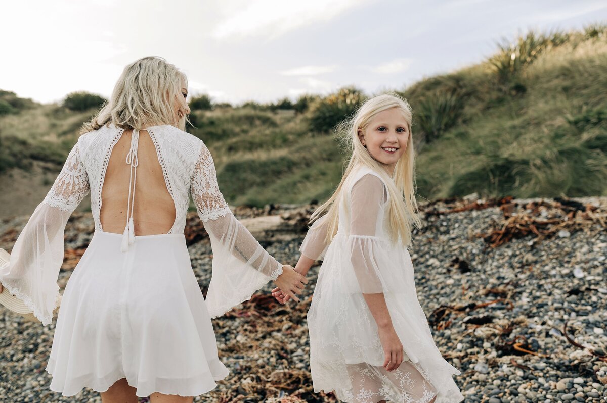 mother daughter riverton new zealand beach portrait family white dresses blonde looking over shoulder