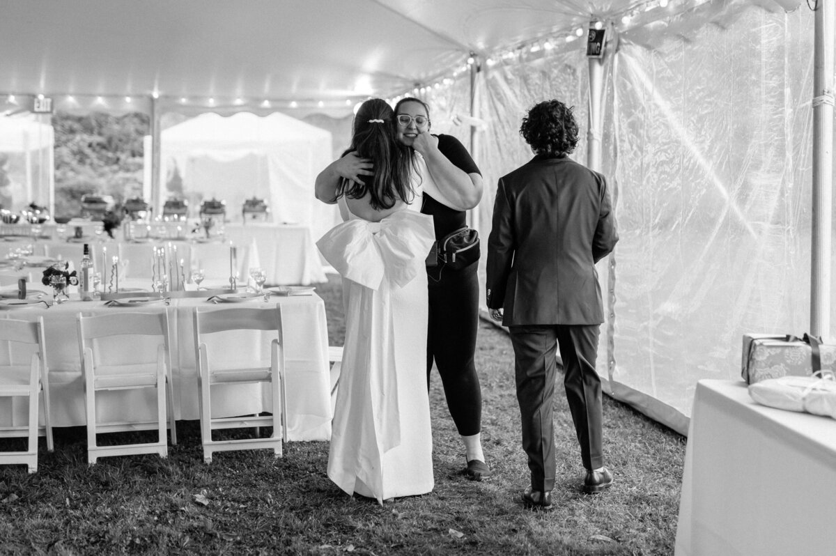 Rachel smiling while hugging bride