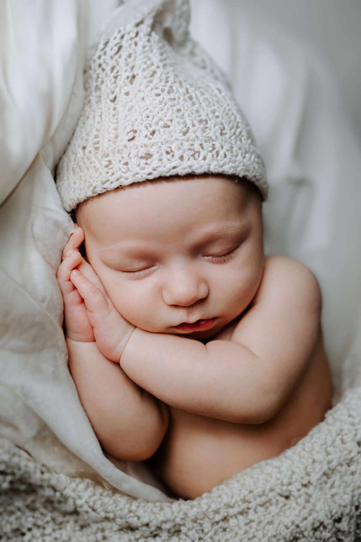 A newborn baby in a knitted hat, captured beautifully by a Pittsburgh newborn photographer.