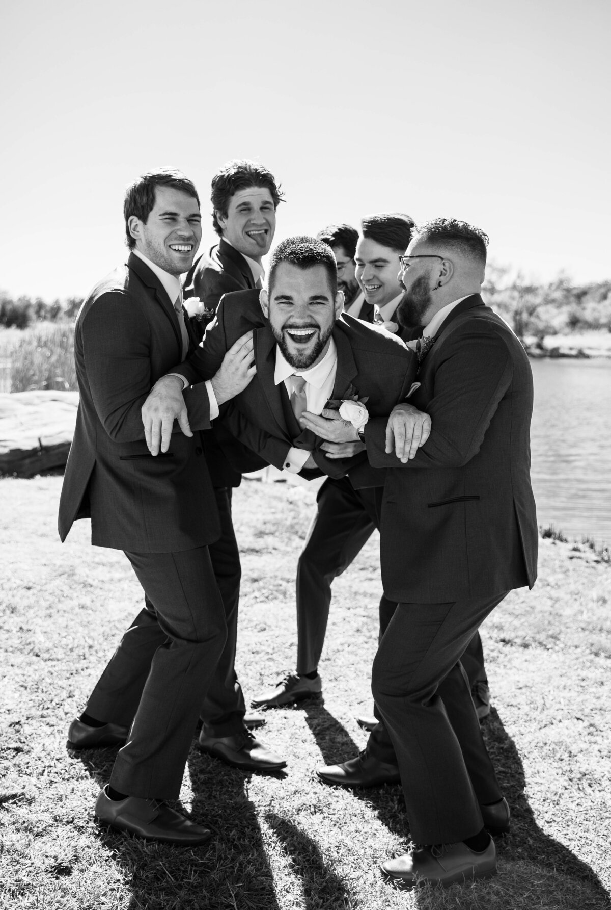 groomsmen holding up groom