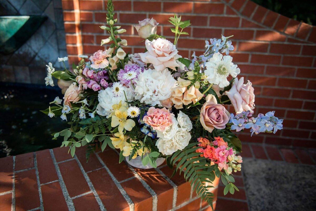 Large focal flower arrangement at an outdoor wedding.