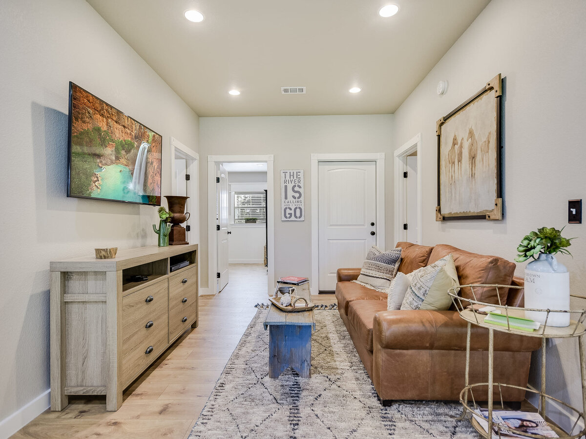 barn living room with brown sofa and tv on wall