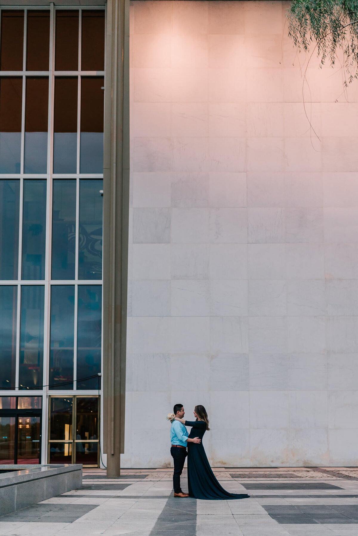 A wide-angle shot of an expecting couple at the Kennedy Center in DC during their maternity session