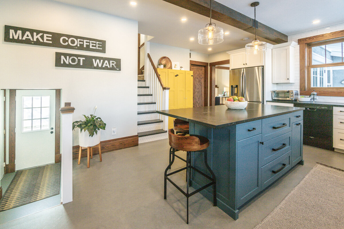 blue kitchen island and yellow cabinets