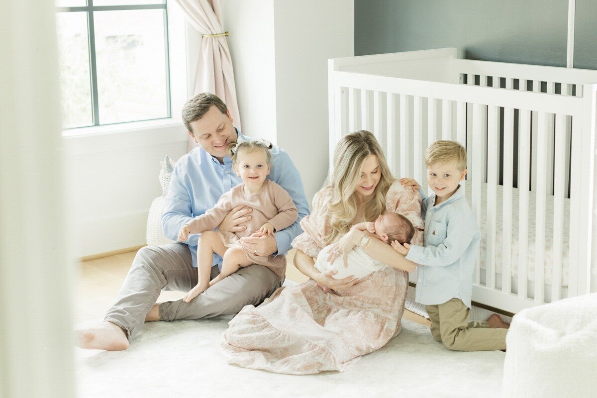 family plays together in nursery for in-home newborn photography