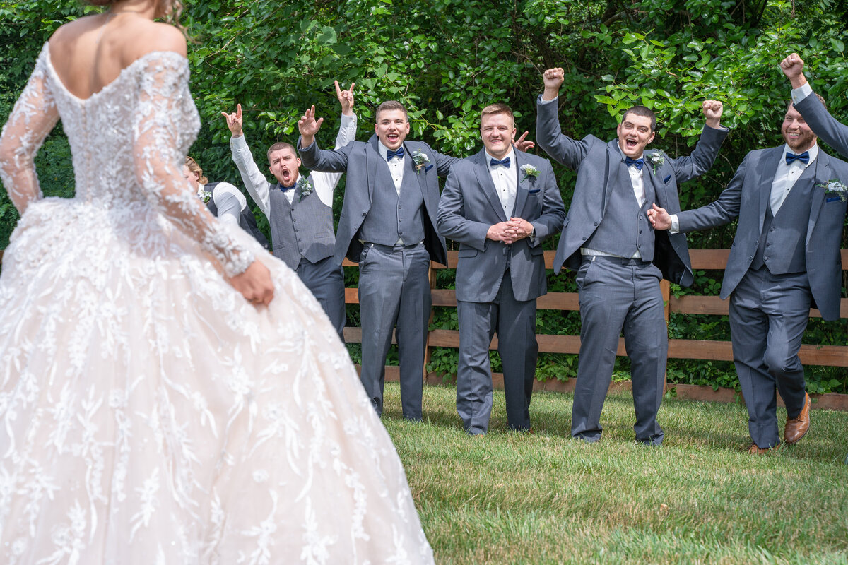The groomsmen at Mahalie and Ryan Bee's wedding at The Old Blue Rooster Event Center LLC in Lithopolis, Ohio, get a first look at the bride. They were really excited about it!