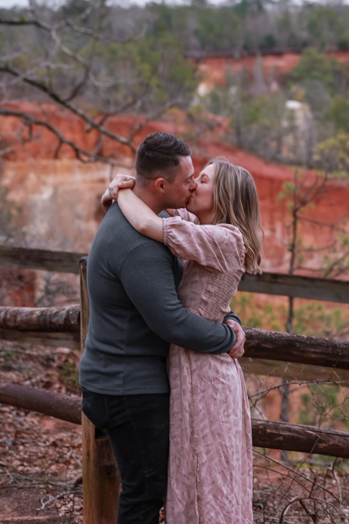 man and woman kissing and holding each other at Providence Canyon State Park by Columbus Georgia engagement photographer Amanda Richardson Photography