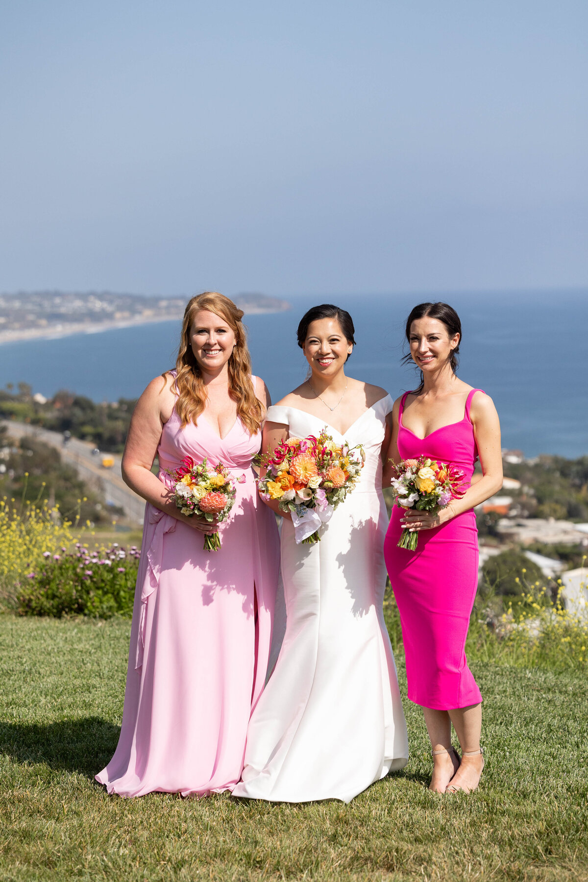 Bride holding a floral bouquet and two bridesmaids