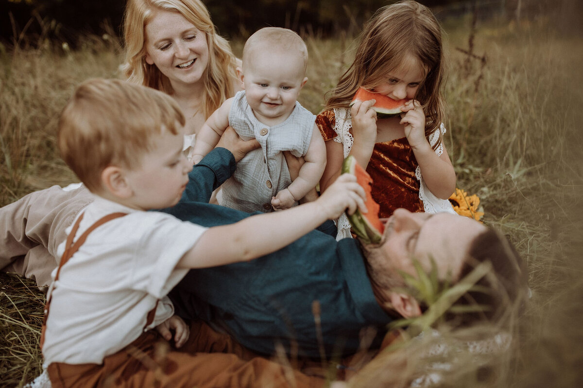 A family playing together in a field at Hyde Farm Park. 