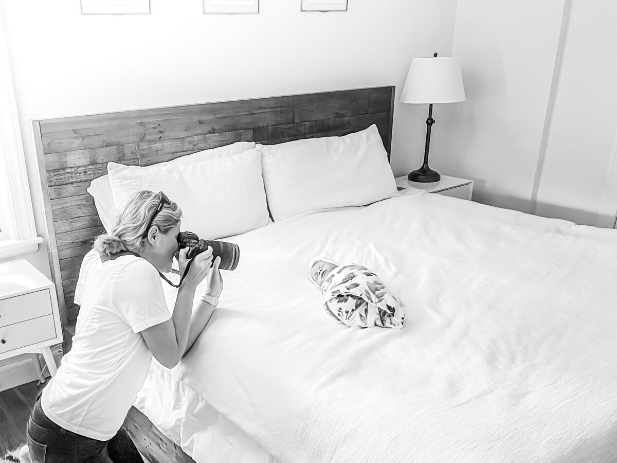 boston newborn photographer takes photo of new baby on bed