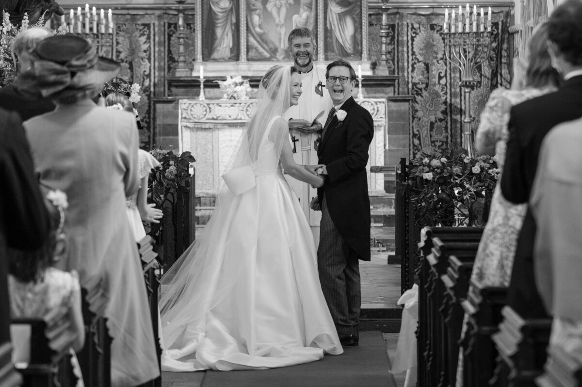 Bride and groom turn to grin at the guests after they're pronounced husband and wife