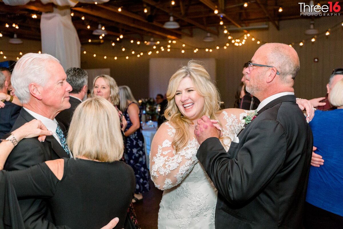 Bride dances with her father among the guests