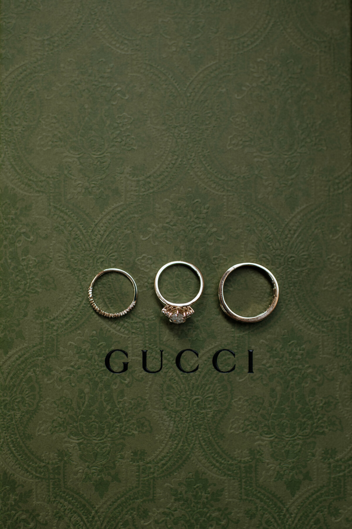 Wedding rings flat lay on green Gucci background