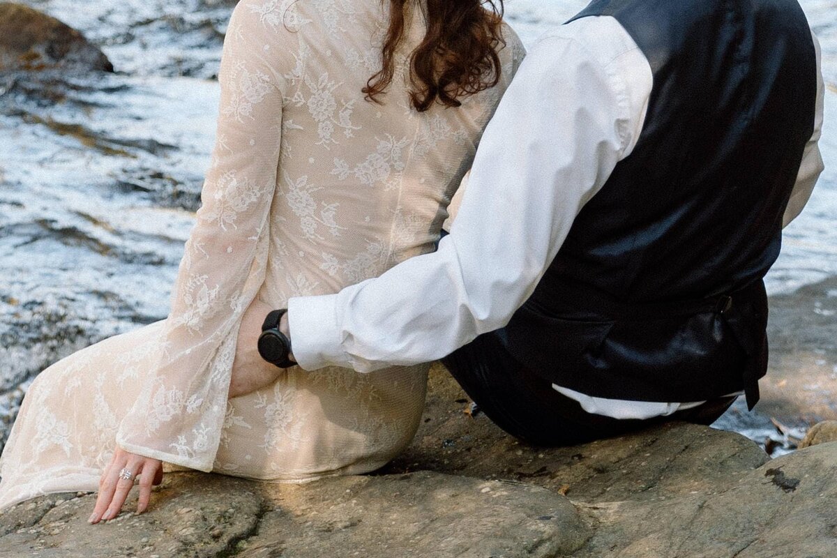couple sitting together on a rock at fall creek falls during elopement