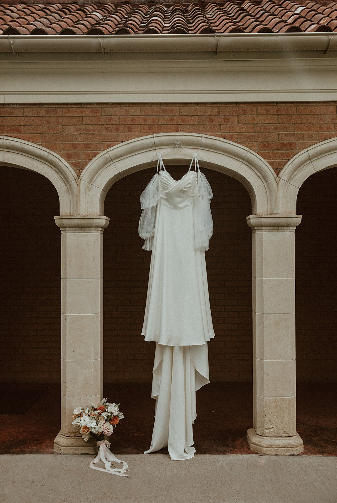 wedding dress hanging in arch 