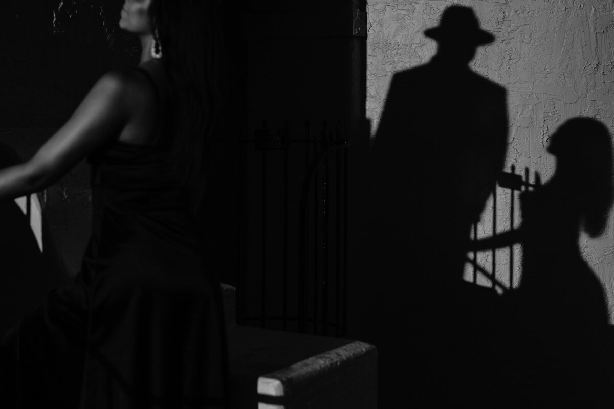 man and woman standing on stairs with shadows on the wall