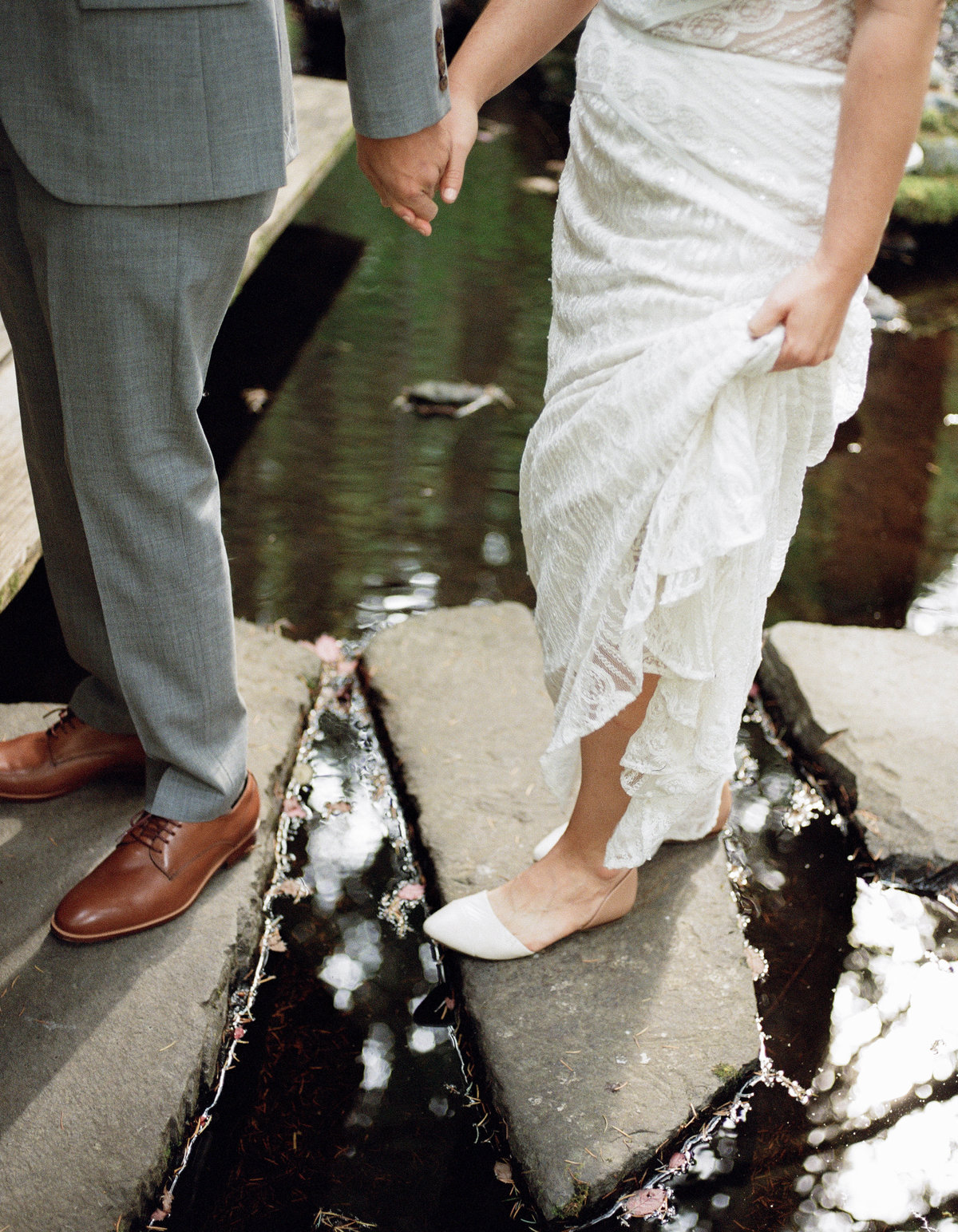 could walks hand in hand over stones on water pond