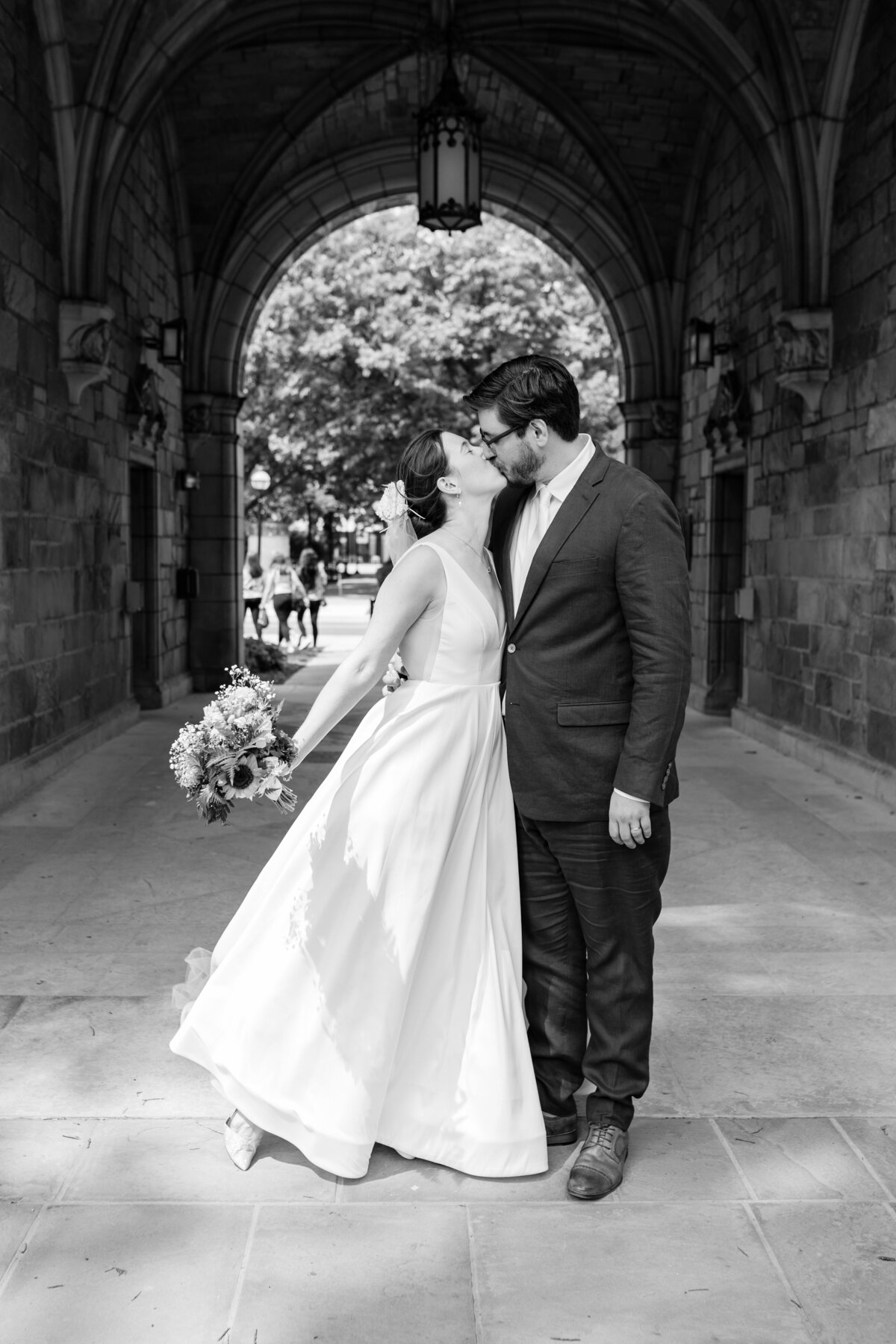 bride and groom kissing in an archway