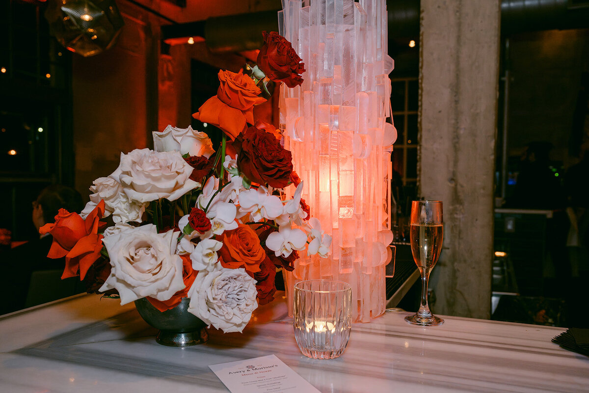 Elegant red and white floral centerpiece accented with tall pillar candles at a San Antonio luxury wedding