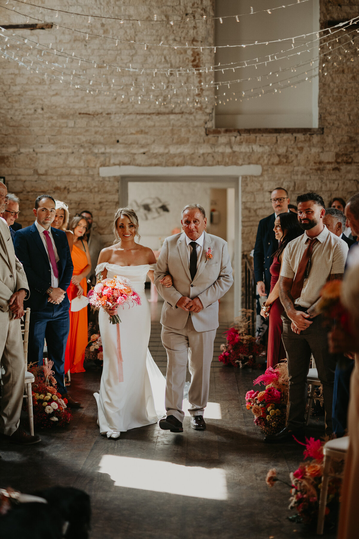 Bride is walked down the aisle at her wedding at Lapstone Barn.