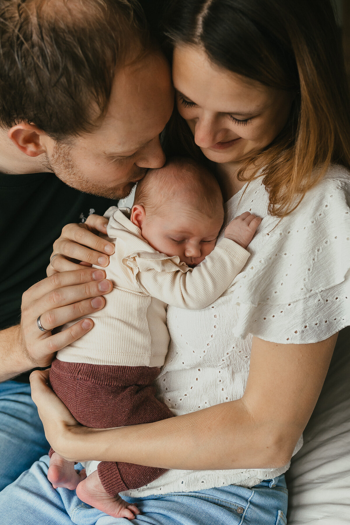 Ouders op bed met pasgeboren baby fotoshoot