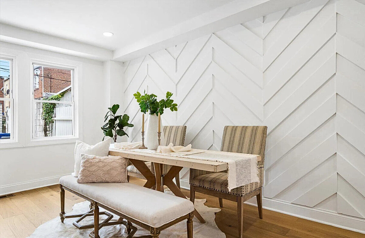 Stylish dining area featuring a custom chevron accent wall, natural wood table, and elegant seating—bringing craftsmanship and modern design together for a warm, inviting space.