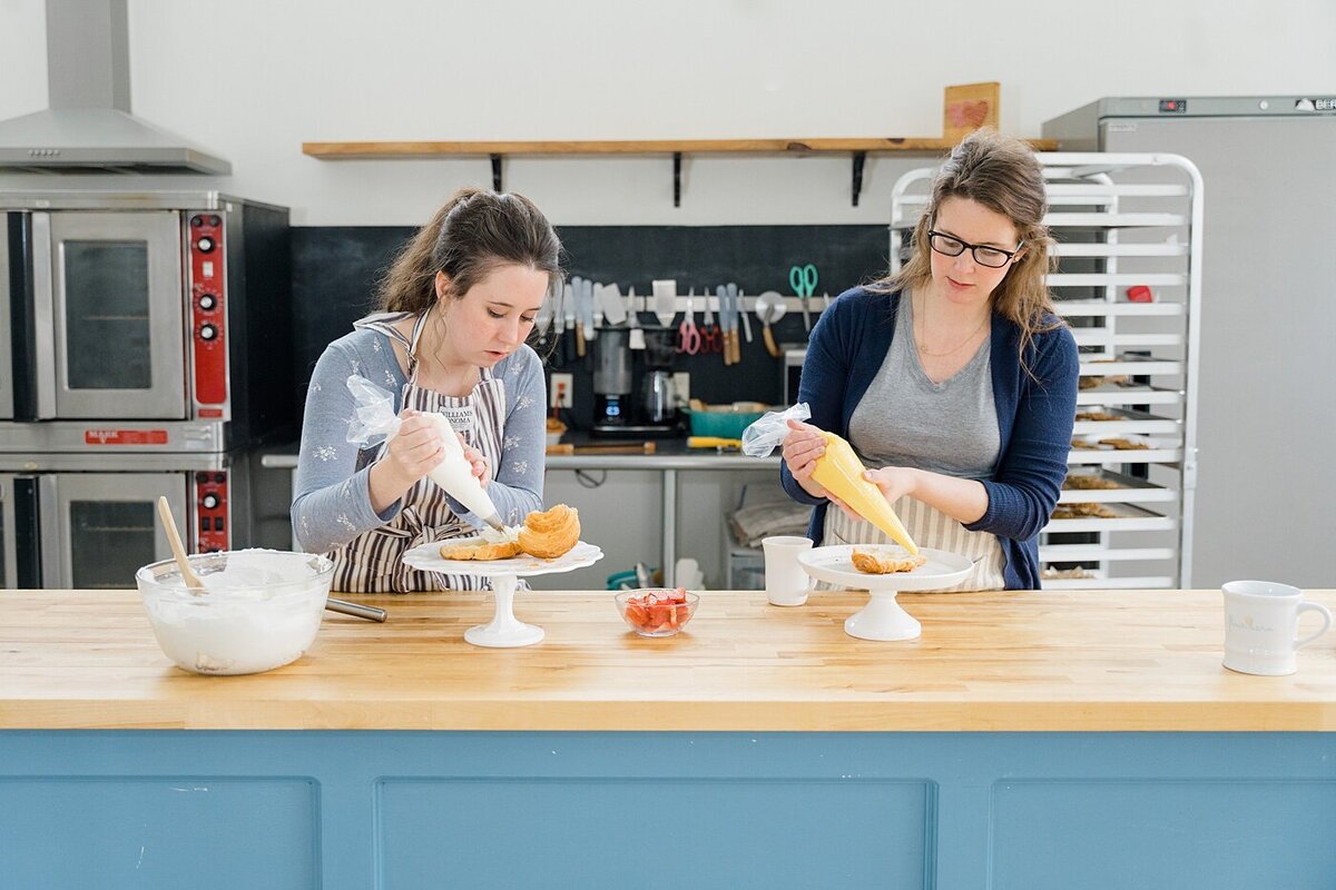 behind the scenes brand photos with two women piping for their bakery captured by brand photographer