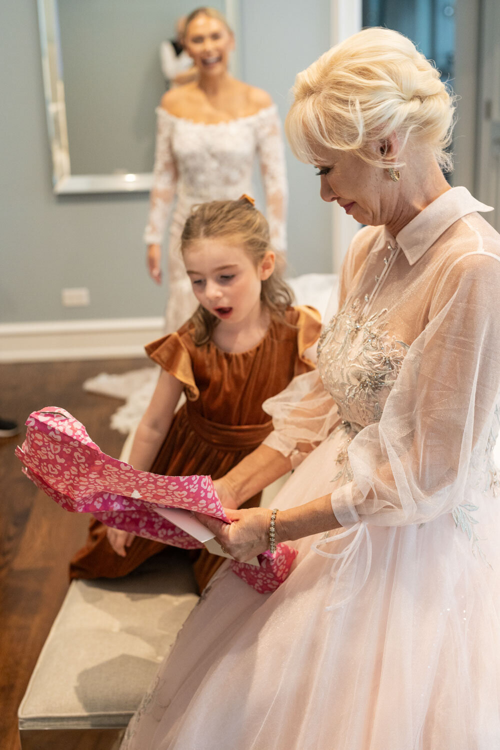 A woman and a little girl are opening a gift