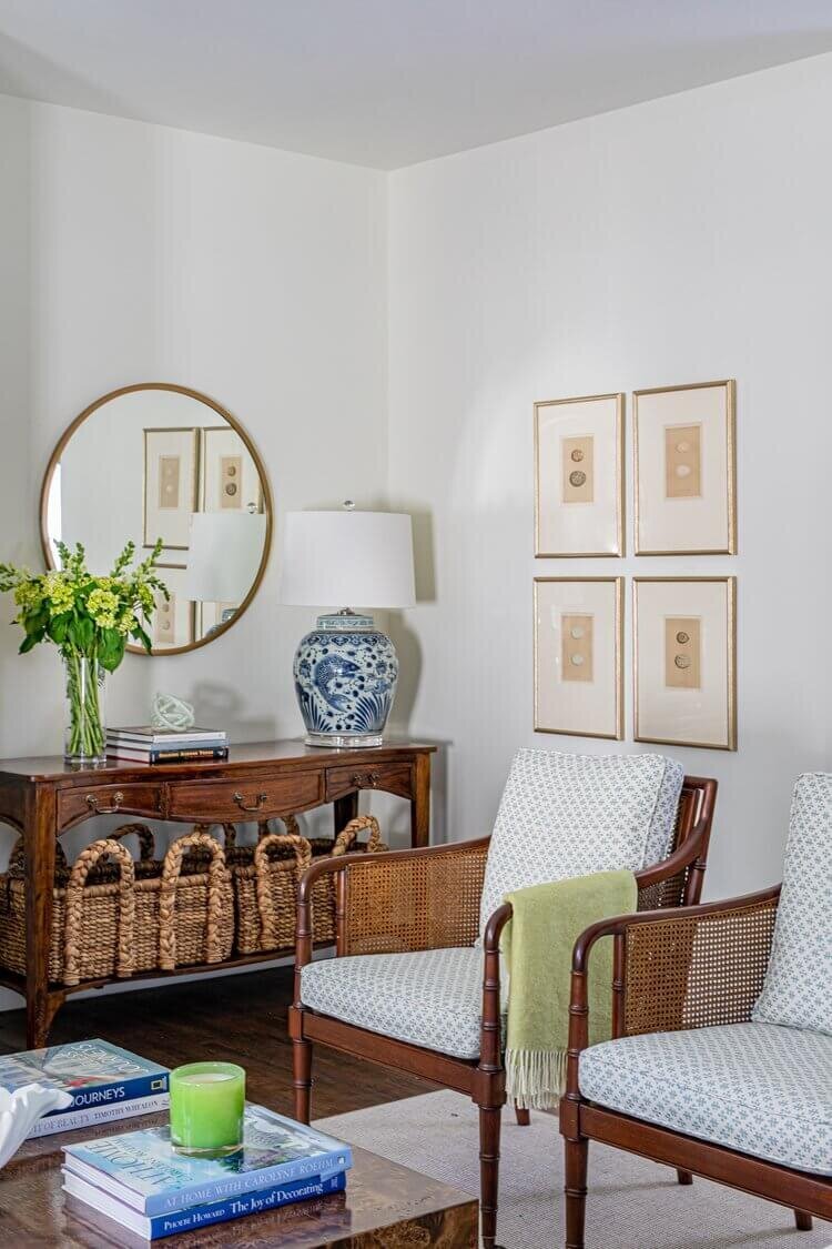 oyster creek studios highland park home accent table with round mirror and wicker baskets in living room